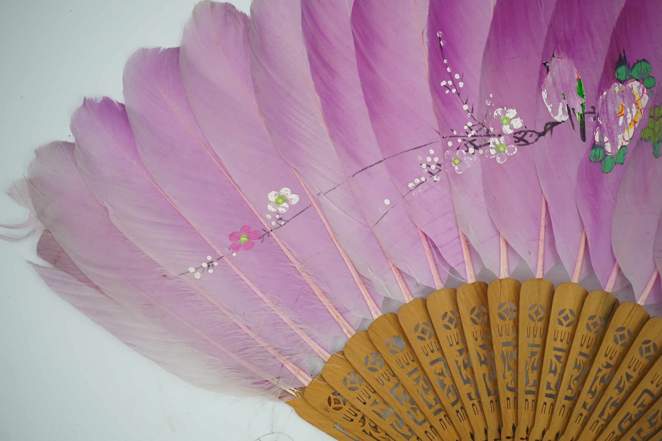 Three 19th century Chinese feather fans: One a carved bone brise black feather fan together with two similar carved sandalwood feather fans, two fans have hand painted decoration on the feathers both sides, the pink feat